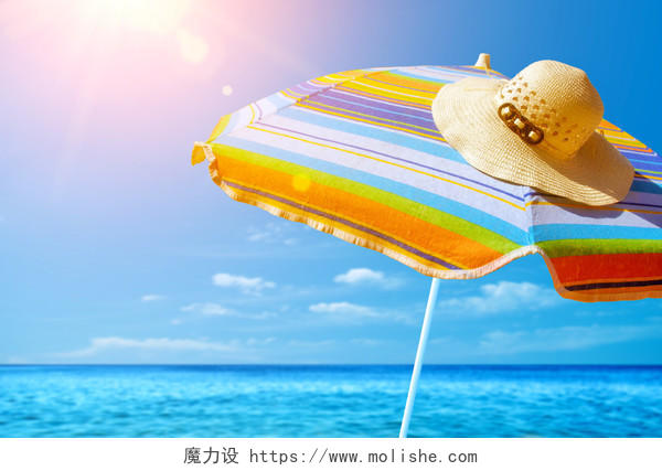 五颜六色的遮阳伞和沙滩上阳光明媚的夏日草帽的细节